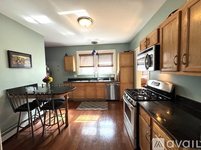 A kitchen with a table and chairs and a stove top oven.