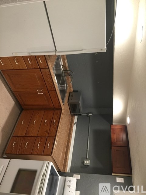 A kitchen with wooden cabinets and a microwave.