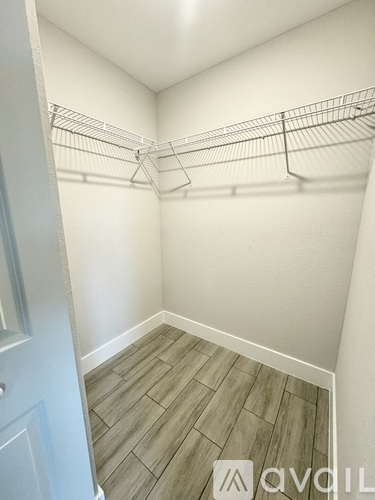 A walk-in closet with a white door and shelves.