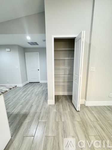 A room with a white door and a wooden floor.