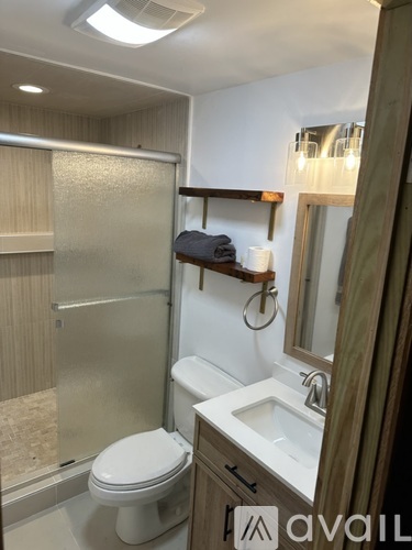 A bathroom with a toilet, sink, and shower.
