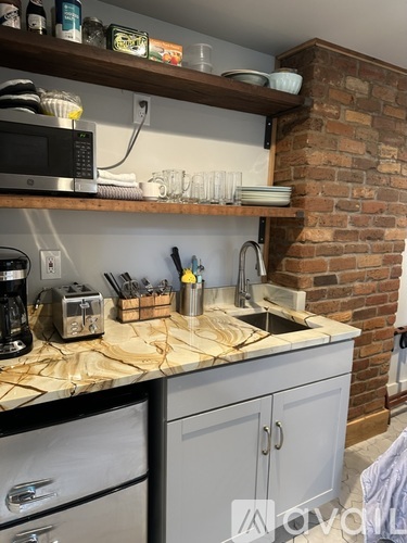 A kitchen with a brick wall and a marble countertop.