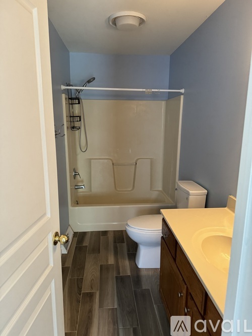 A bathroom with a toilet, sink, and shower.