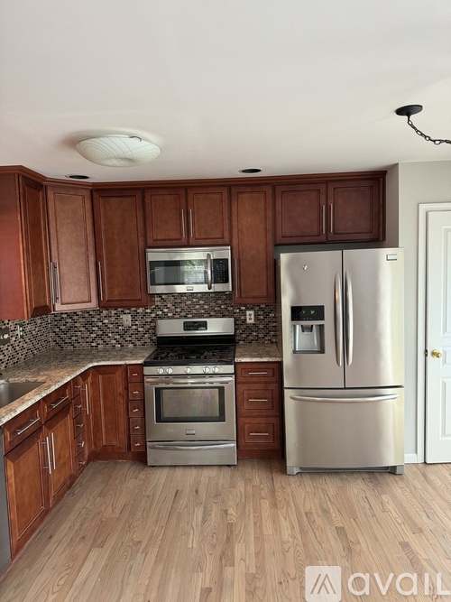 A kitchen with wooden cabinets and stainless steel appliances.