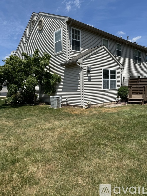 A house with a striped exterior and a tree in front.