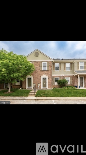 A brick house with a tree in front of it.