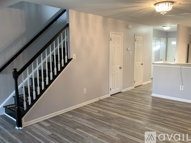 A spacious room with a staircase and a mirror on the wall.