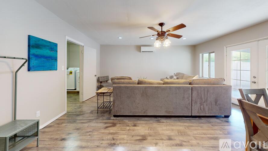 A living room with a grey couch and a ceiling fan.