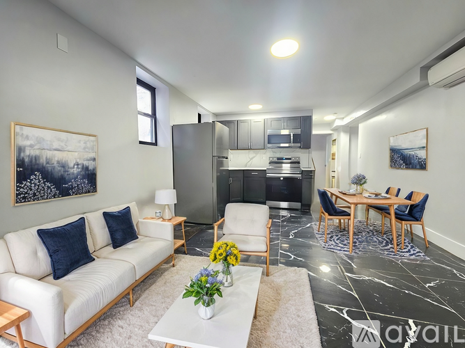 A modern living room with a white sofa, a coffee table, and a dining area in the background.