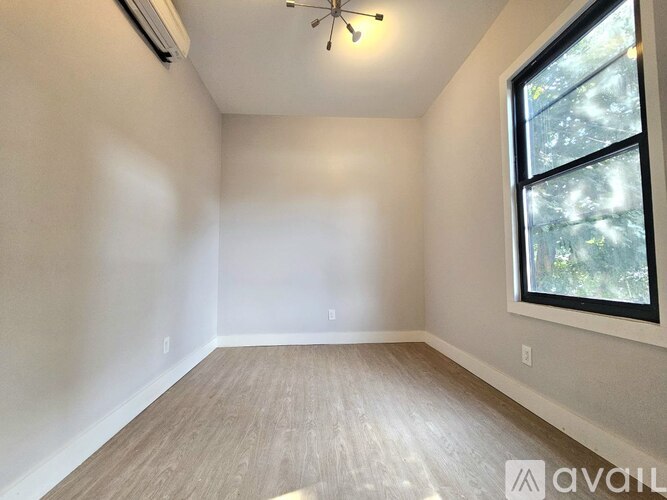 A room with a window and a ceiling fan.