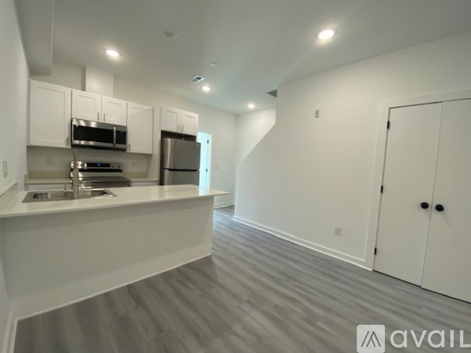 A modern kitchen with white cabinets and stainless steel appliances.