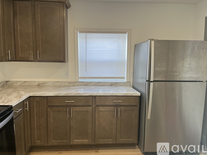 A kitchen with wooden cabinets and a marble countertop.