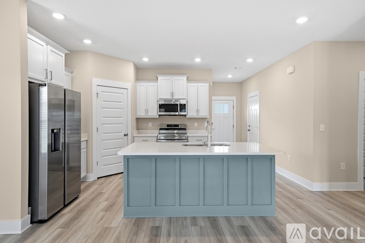 A kitchen with a blue island and white cabinets.