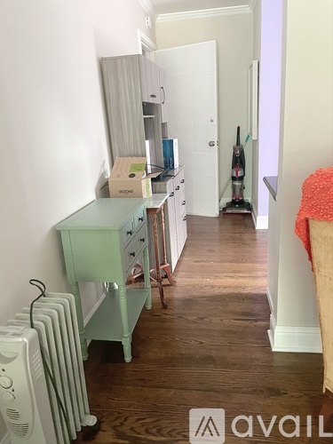 A room with a green desk and a white radiator.