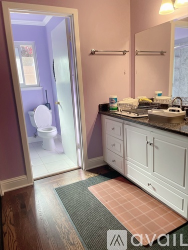 A bathroom with a toilet, sink, and mirror.