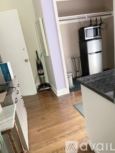 A kitchen with a white fridge and a black counter top.