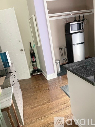 A kitchen with a white fridge and a black counter top.