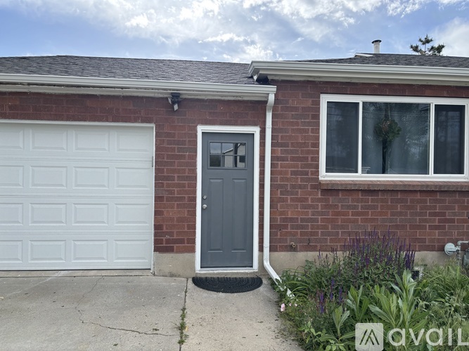 A house with a grey door and a white garage door.