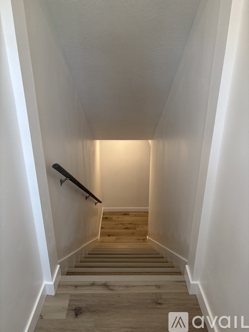 A staircase with wooden steps and white walls.