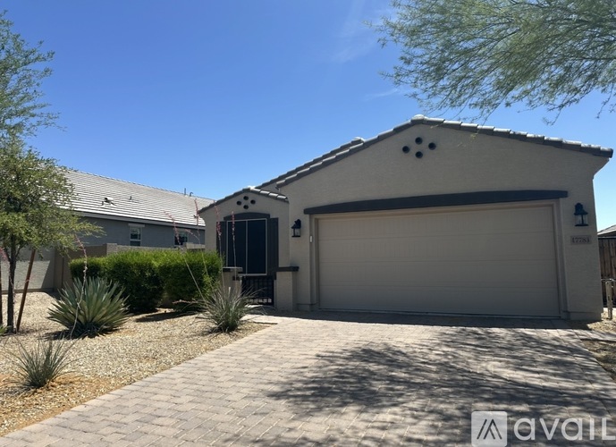 A house with a garage door and a driveway in front.