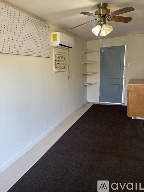 A room with a ceiling fan and a sign on the wall.