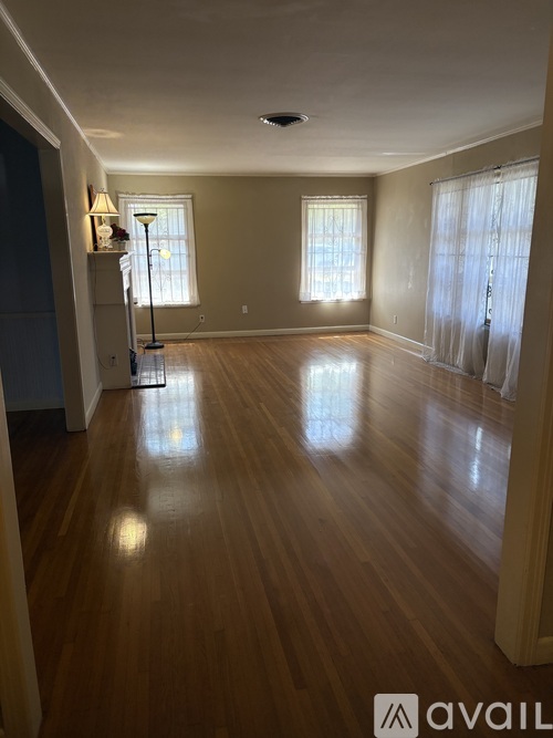A room with wooden floors and two windows.