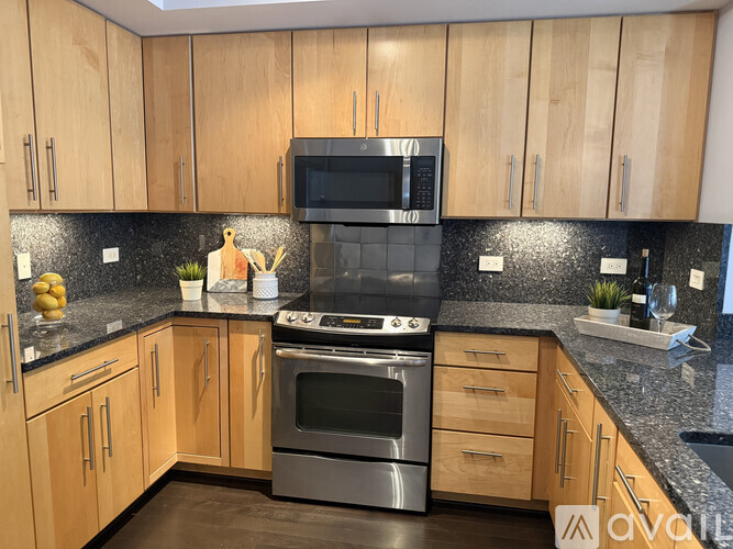 A kitchen with wooden cabinets and a black countertop.