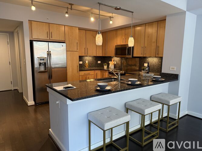 A kitchen with a white island and three stools.