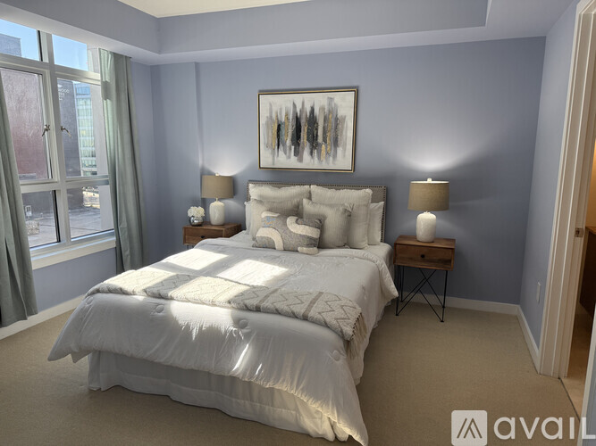 A bedroom with a large bed and a painting on the wall.