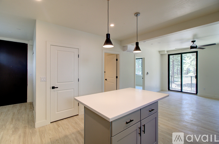 A kitchen with a white countertop and cabinets, and a ceiling fan.