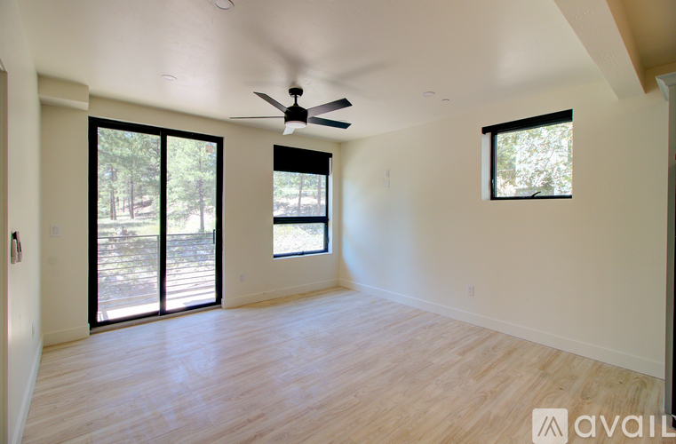 A spacious room with a ceiling fan and sliding glass doors.