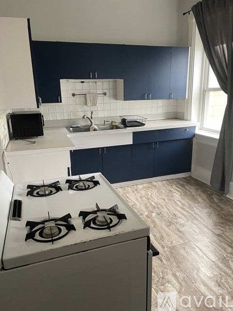 A kitchen with a white stove and blue cabinets.