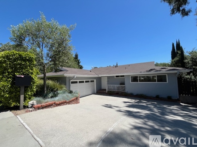 A house with a garage and a driveway in front of it.