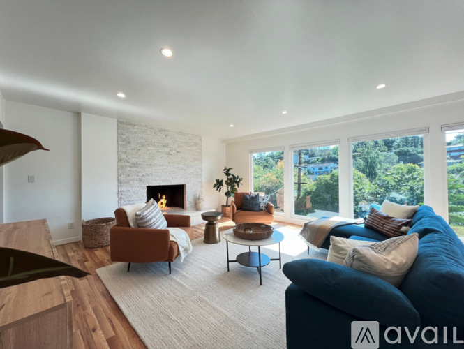 A living room with a fireplace and a blue couch.