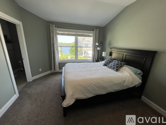 A bedroom with a large bed and a window overlooking a street.