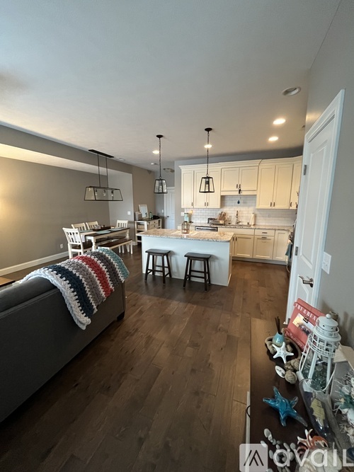 A living room with a grey couch and a white table.