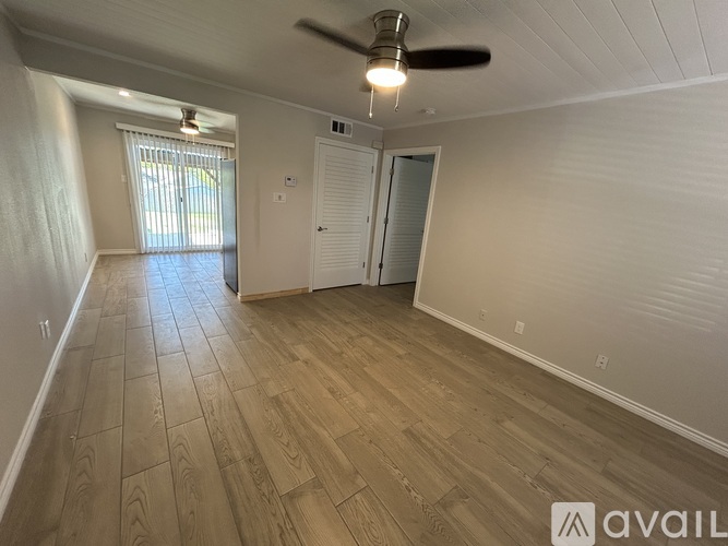 A room with wooden flooring and a ceiling fan.