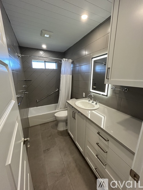 A bathroom with a toilet, sink, and mirror.