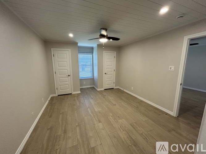 A room with wooden flooring and a ceiling fan.