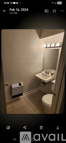 A bathroom with a toilet, sink, and mirror.