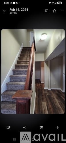 A staircase with a wooden banister and a carpeted runner.