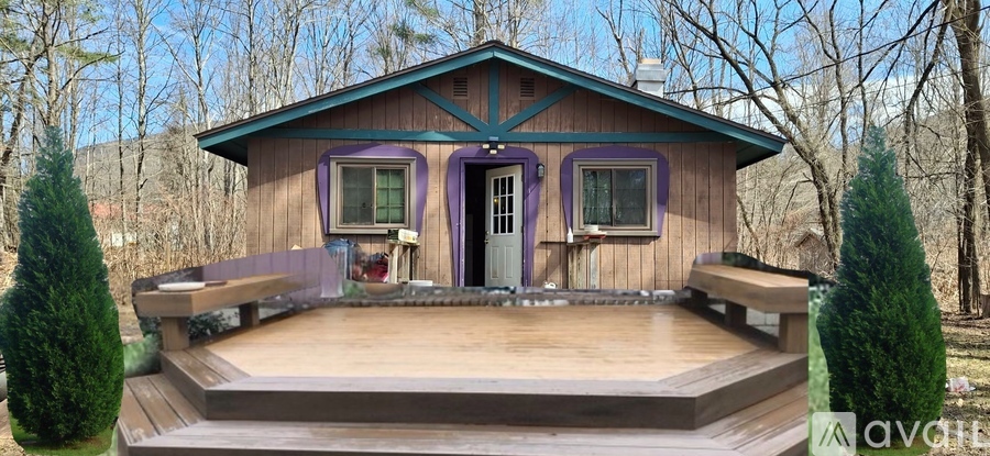 A small wooden cabin with a porch and a balcony.