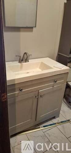 A white sink in a bathroom with a silver faucet.