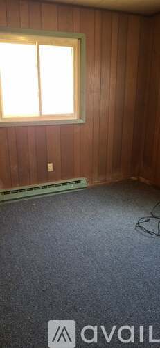A room with wooden walls and a window.