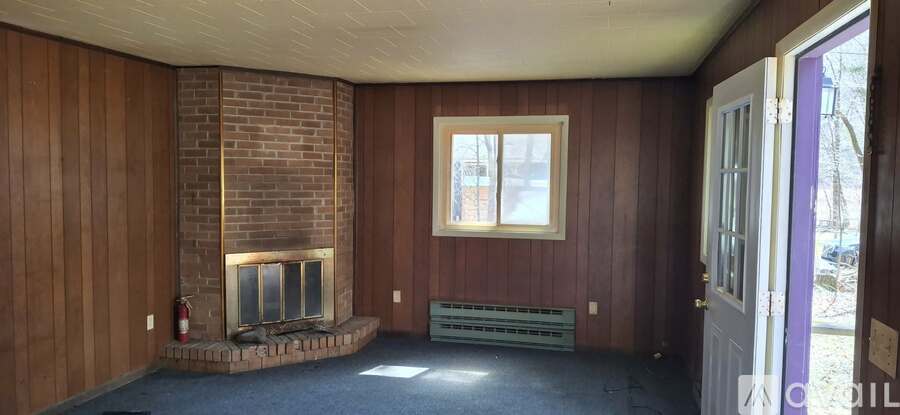 A room with a fireplace and a window.