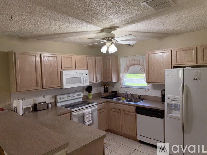A kitchen with wooden cabinets and a white fridge.