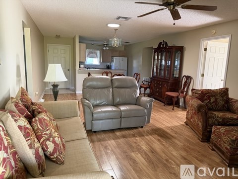 A living room with a beige couch and a wooden floor.