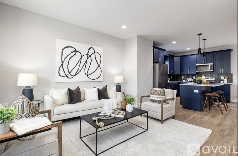 A modern living room with a white couch, a coffee table, and a large abstract painting on the wall.