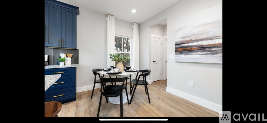 A dining area with a table and chairs in a room.