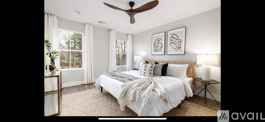 A bedroom with a large bed and a ceiling fan.